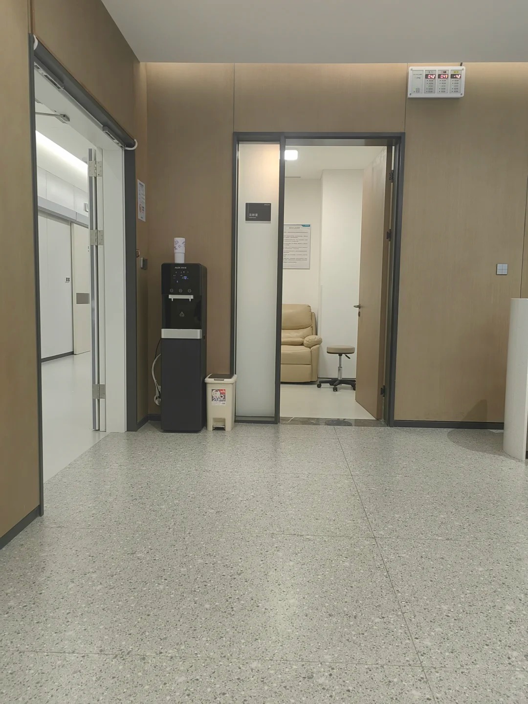 Quiet clinical corridor with water dispenser and consultation room